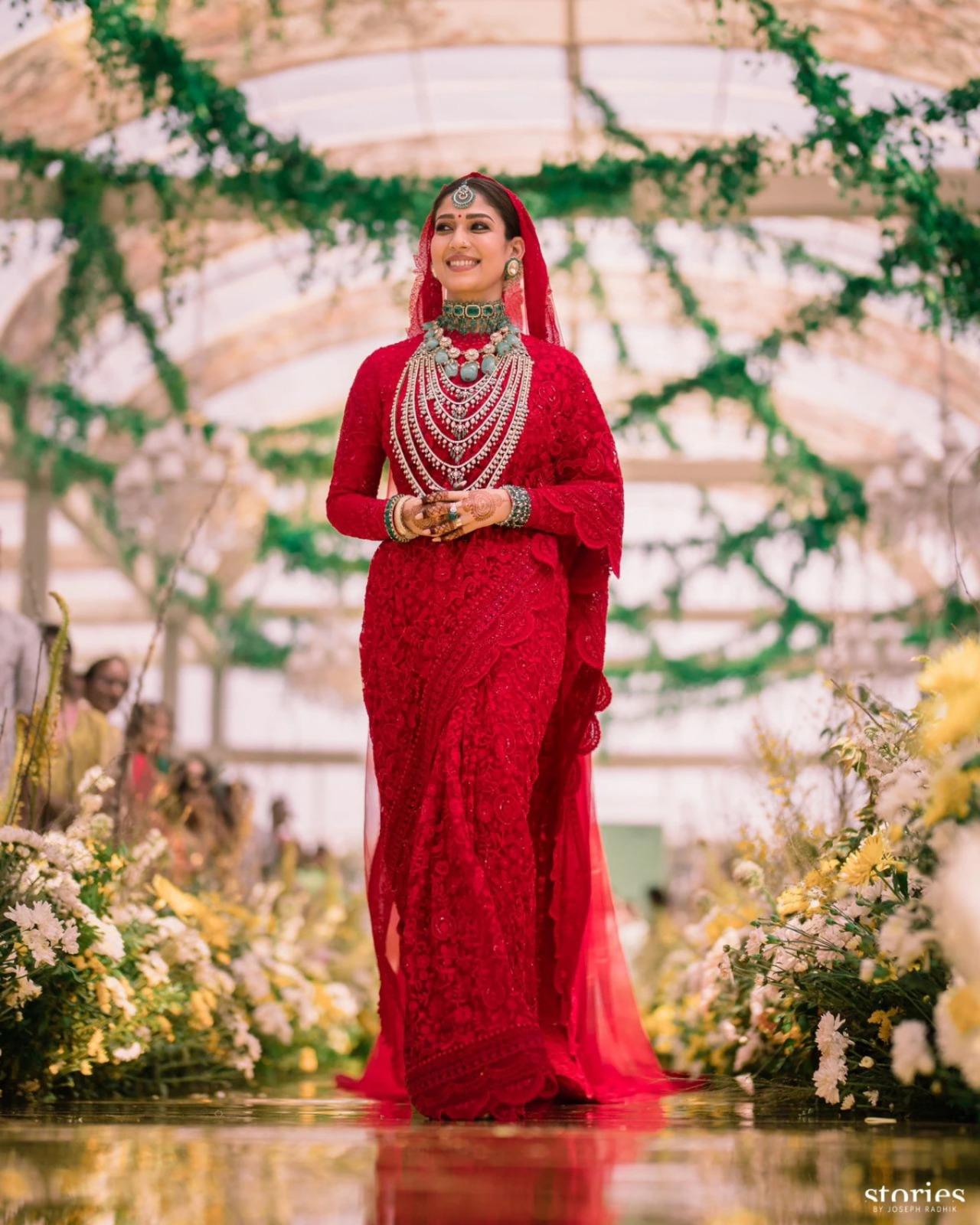 Nayanthara rocked a heavily-embroidered red saree for her big day. The embroidery on her saree was inspired by the architecture of Hoysala temples. She glammed up her bridal finery with emerald jewels. Paired with elaborate temple jewellery and a sheer red veil, her look felt nothing short of divine.